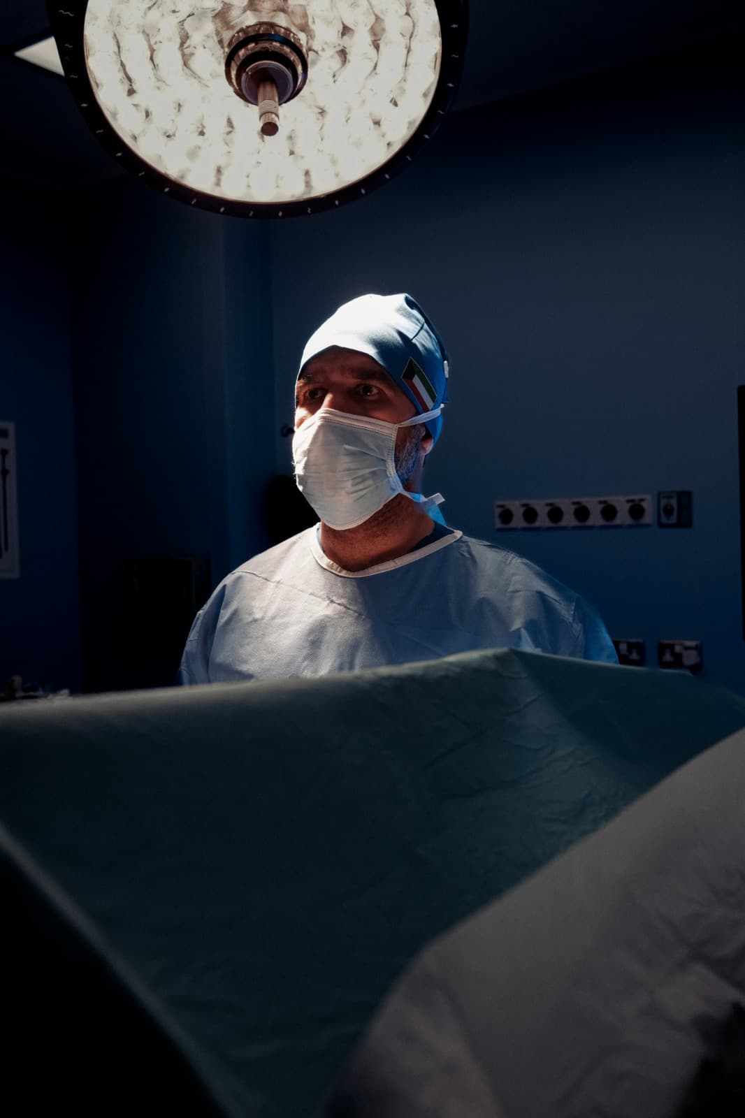 Prof. Jamal in surgical gown and mask under the operating lights