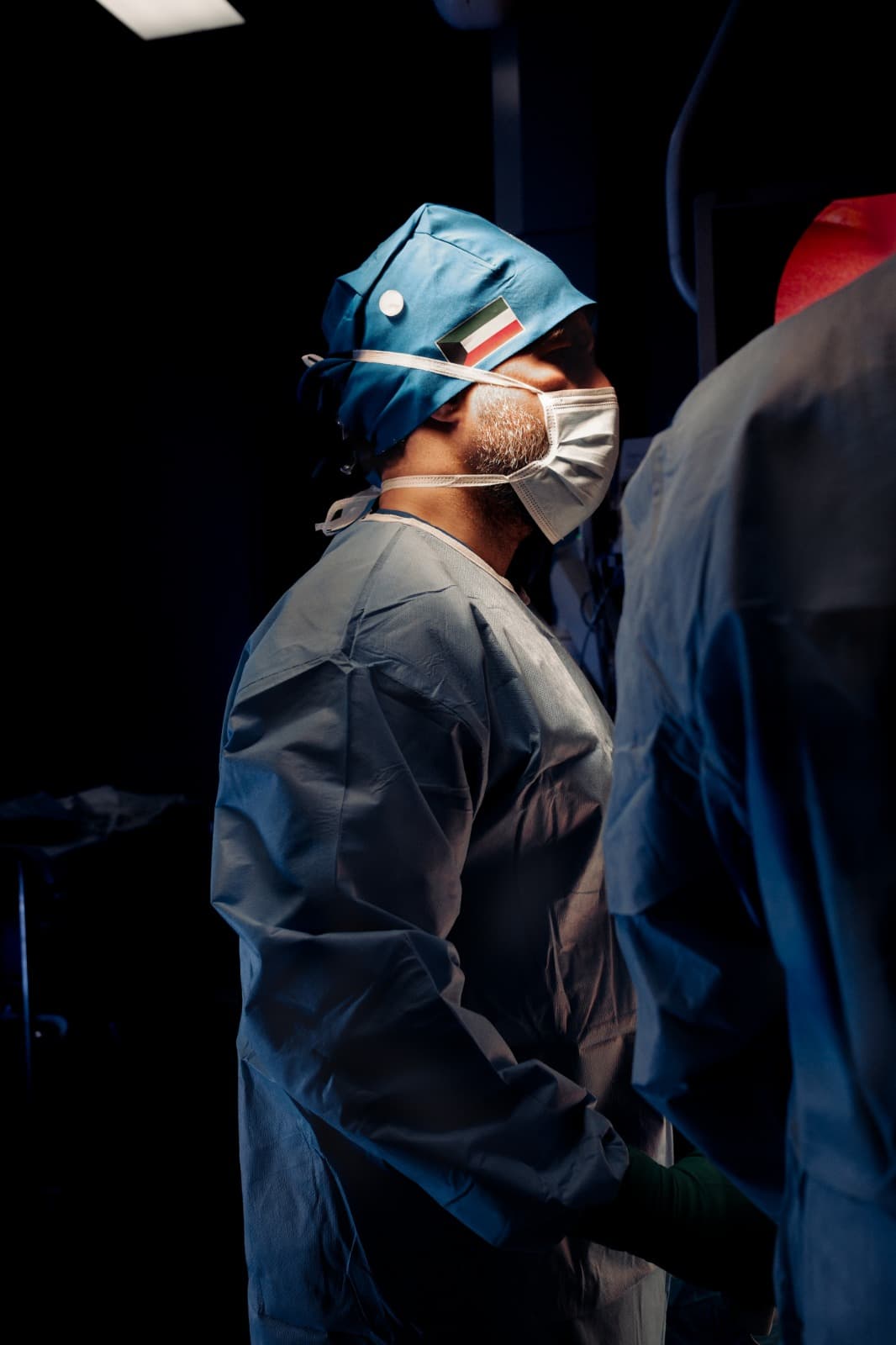 Profile of Prof. Jamal in theatre wearing a Kuwait flag surgical cap