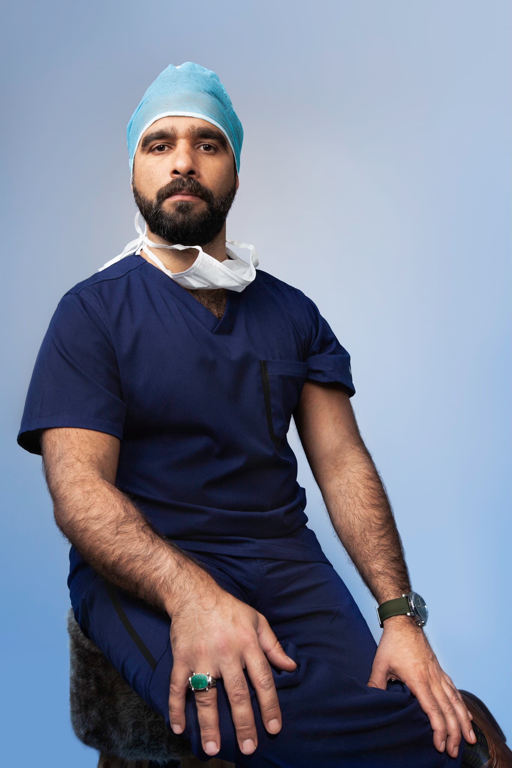 Prof. Jamal in surgical scrubs on a blue background